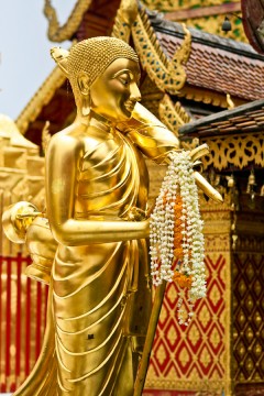 Figurka Buddy w świątyni Wat Phrathat Doi Suthep. Legenda głosi, że świątynia powstała w miejscu, gdzie biały słoń, któremu do grzbietu przywiązano relikwię Buddy zatrzymał się, zatrąbił trzy razy i umarł. (Fot. Kasia Boni)