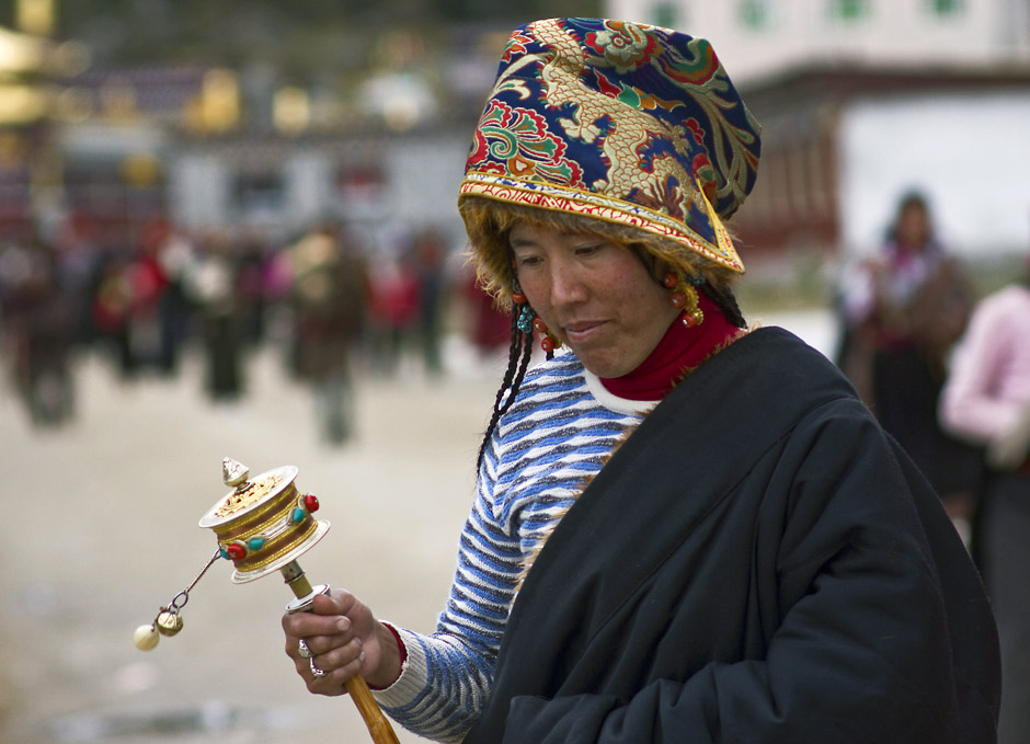 16. CHINY, Dzogchen Gompa. Tybetańska kobiety rzadko odkładają swoje młynki modlitewne, które często są dziełami sztuki, wykonanymi z metali szlachetnych i ozdobionymi koralami i turkusami. (Fot. Magda Świder)